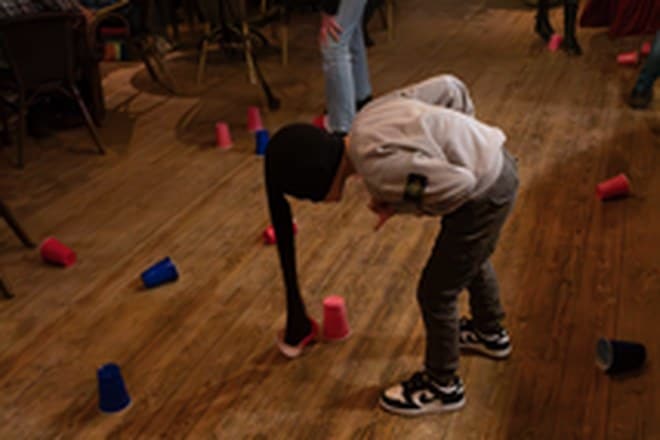 Deelnemer doet een Minute to Win It opdracht tijdens een groepsuitje bij Condao